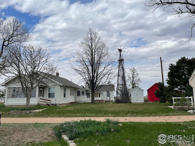 31496 County Road 29, Greeley, CO 80631 - view of front facade featuring a chimney, a storage unit, and a front lawn