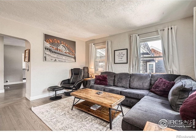 4009 W 52nd Ave, Denver, CO 80212 - living area featuring arched walkways, wood finished floors, and a textured ceiling