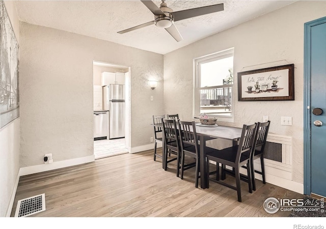 4009 W 52nd Ave, Denver, CO 80212 - dining room featuring a textured wall, light wood finished floors, a ceiling fan, and a textured ceiling