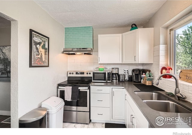 4009 W 52nd Ave, Denver, CO 80212 - kitchen featuring appliances with stainless steel finishes, wall chimney range hood, tasteful backsplash, white cabinets, and a textured ceiling