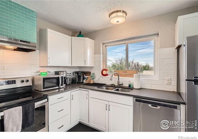 4009 W 52nd Ave, Denver, CO 80212 - kitchen with appliances with stainless steel finishes, white cabinets, dark countertops, tasteful backsplash, and exhaust hood