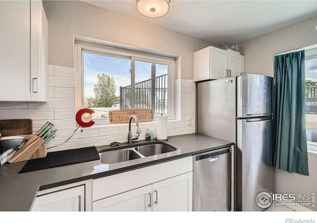 4009 W 52nd Ave, Denver, CO 80212 - kitchen featuring dishwasher, dark countertops, white cabinets, backsplash, and healthy amount of natural light