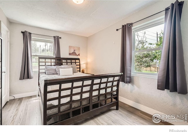 4009 W 52nd Ave, Denver, CO 80212 - bedroom featuring wood finished floors, a textured ceiling, and a textured wall