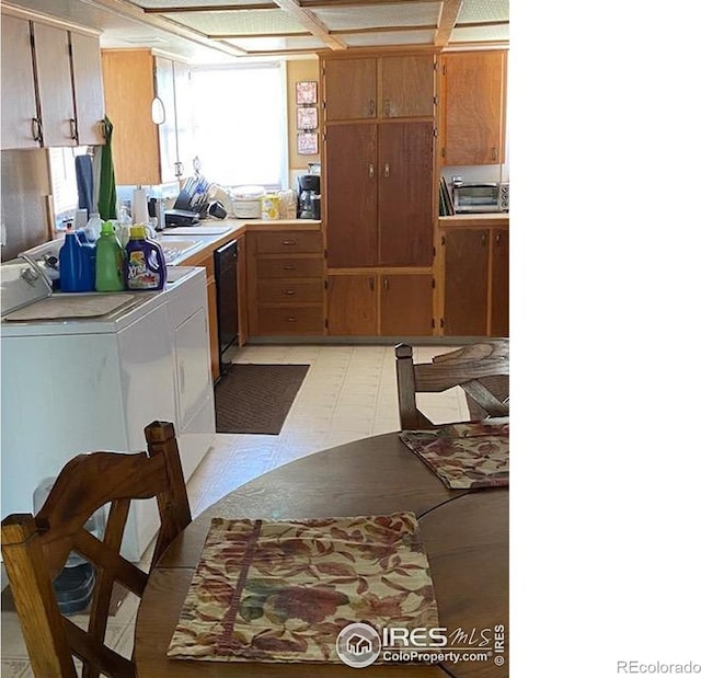 205-207 W 3rd Ave, Wiggins, CO 80654 - kitchen with washing machine and dryer, light countertops, light floors, dishwasher, and brown cabinetry