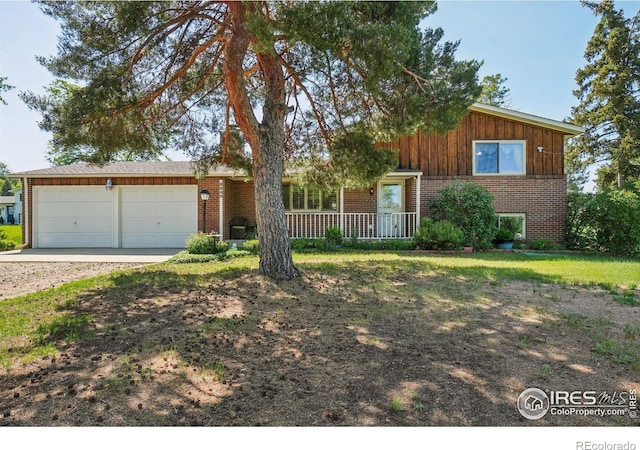 8840 Niwot Rd, Niwot, CO 80503 - view of front of home with brick siding, a garage, dirt driveway, and a porch