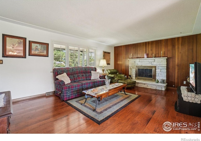 8840 Niwot Rd, Niwot, CO 80503 - living room featuring dark wood-style flooring, wood walls, a fireplace, and baseboard heating