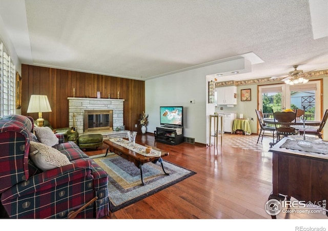 8840 Niwot Rd, Niwot, CO 80503 - living area with ceiling fan, wood finished floors, wood walls, and a fireplace