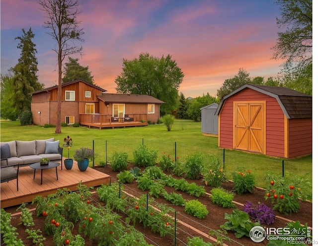 8840 Niwot Rd, Niwot, CO 80503 - yard at dusk featuring a storage shed, a vegetable garden, a lawn, a wooden deck, and an outdoor living space