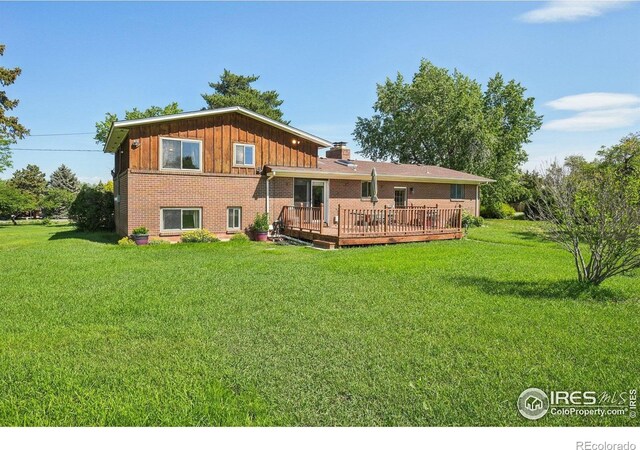 8840 Niwot Rd, Niwot, CO 80503 - back of property with a deck, brick siding, a yard, and board and batten siding