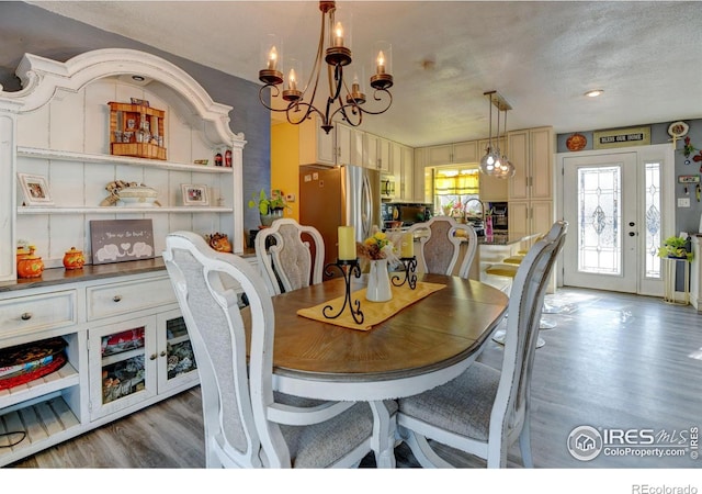 7970 Wolff Ct, Westminster, CO 80030 - dining room featuring wood finished floors, a chandelier, and a textured ceiling