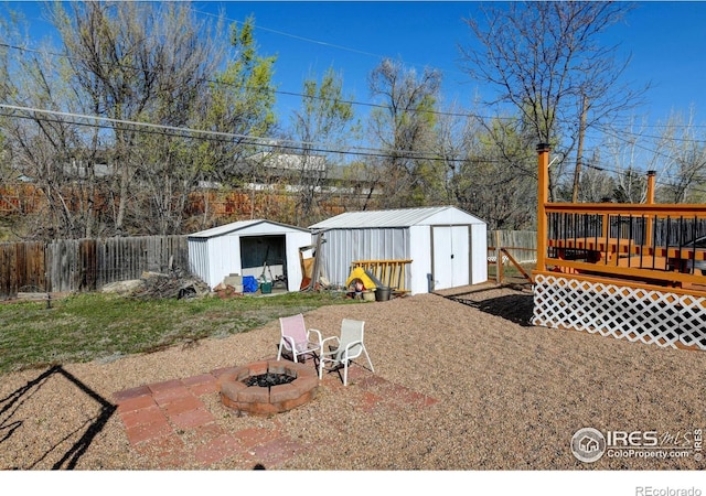 7970 Wolff Ct, Westminster, CO 80030 - fenced backyard featuring a storage unit, an outdoor fire pit, and a wooden deck
