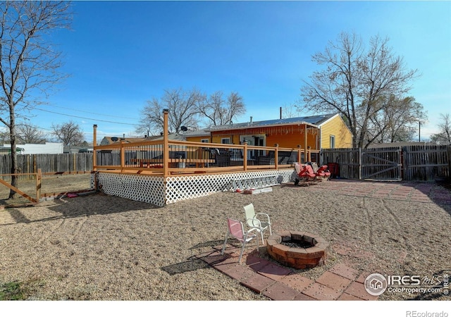 7970 Wolff Ct, Westminster, CO 80030 - rear view of property with a fenced backyard, a gate, a deck, and an outdoor fire pit