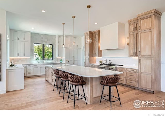 1126 W Enclave Cir, Louisville, CO 80027 - kitchen featuring backsplash, a breakfast bar area, light wood-type flooring, and recessed lighting