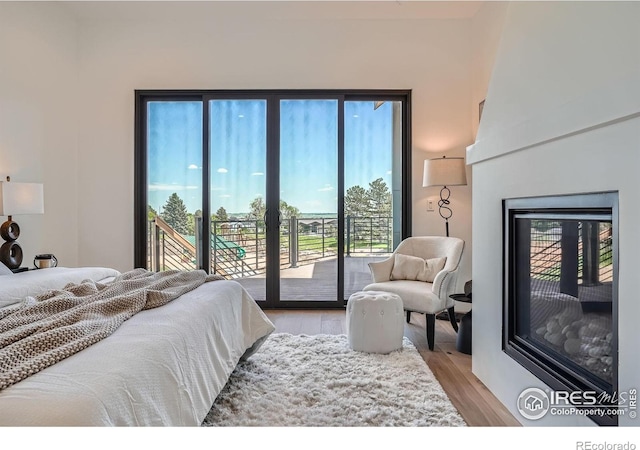 1126 W Enclave Cir, Louisville, CO 80027 - bedroom with access to outside, light wood-type flooring, and a glass covered fireplace