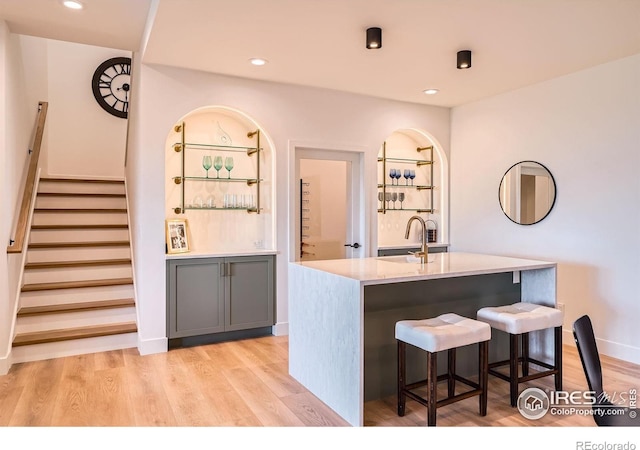 1126 W Enclave Cir, Louisville, CO 80027 - kitchen with a kitchen island with sink, light countertops, recessed lighting, light wood-style flooring, and a breakfast bar area