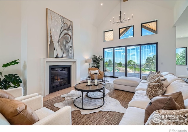 1126 W Enclave Cir, Louisville, CO 80027 - living area featuring high vaulted ceiling, a glass covered fireplace, a chandelier, and wood finished floors