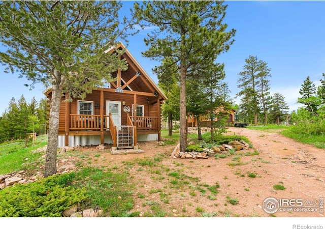 90 Woccon Ct, Red Feather Lakes, CO 80545 - view of front of house featuring covered porch, stairway, and dirt driveway