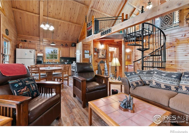 90 Woccon Ct, Red Feather Lakes, CO 80545 - living room with high vaulted ceiling, wooden walls, a wood ceiling with exposed beams, light wood-type flooring, and stairs