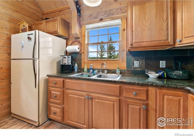 90 Woccon Ct, Red Feather Lakes, CO 80545 - kitchen featuring freestanding refrigerator, wood walls, tasteful backsplash, lofted ceiling, and light wood-type flooring