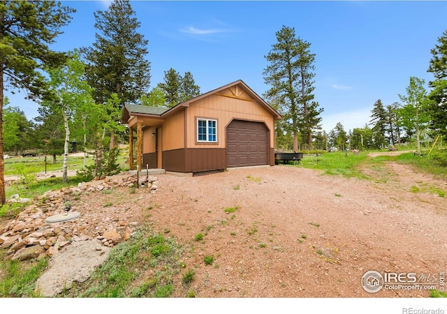 90 Woccon Ct, Red Feather Lakes, CO 80545 - view of side of property featuring dirt driveway and an attached garage