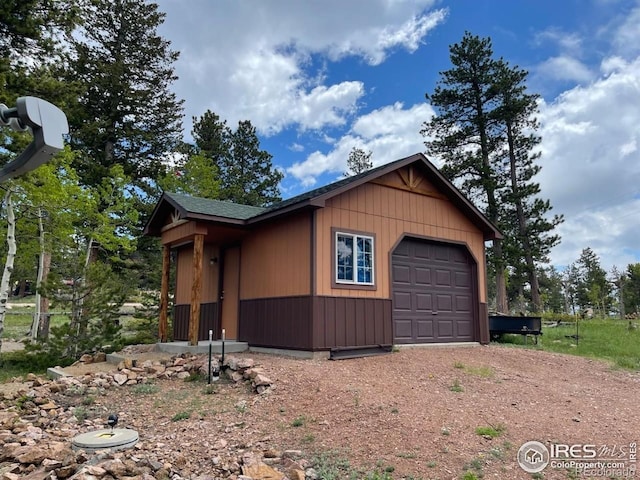 90 Woccon Ct, Red Feather Lakes, CO 80545 - view of side of property featuring dirt driveway, a detached garage, and an outdoor structure