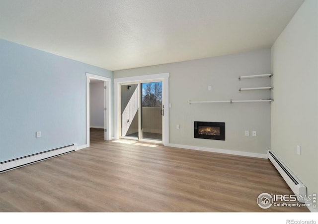 512 E Monroe Dr Unit 329, Fort Collins, CO 80525 - unfurnished living room with baseboard heating, wood finished floors, and a glass covered fireplace