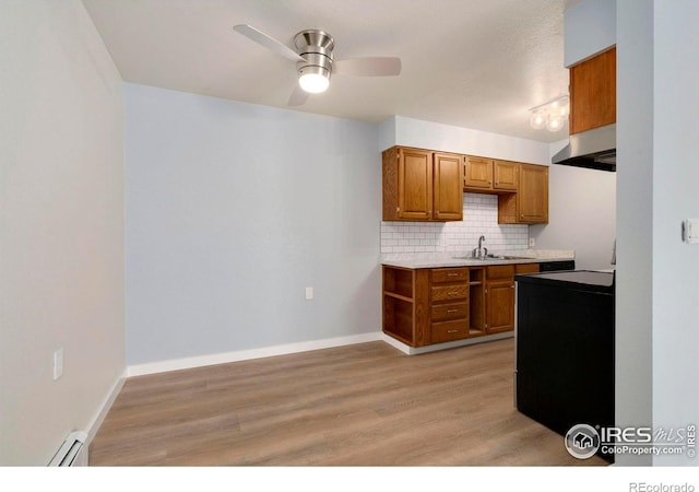 512 E Monroe Dr Unit 329, Fort Collins, CO 80525 - kitchen with a baseboard heating unit, exhaust hood, brown cabinetry, and backsplash