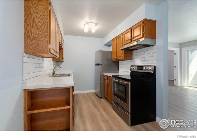 512 E Monroe Dr Unit 329, Fort Collins, CO 80525 - kitchen featuring stainless steel appliances, under cabinet range hood, light wood-style floors, light countertops, and decorative backsplash
