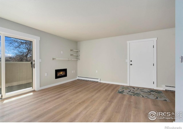 512 E Monroe Dr Unit 329, Fort Collins, CO 80525 - unfurnished living room with a baseboard radiator, wood finished floors, and a glass covered fireplace