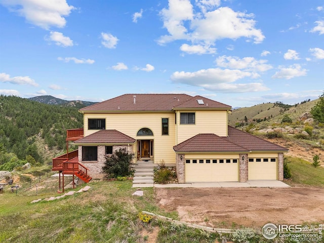 366 N Rim Rd, Livermore, CO 80536 - view of front of home featuring dirt driveway, a mountain view, a garage, a tiled roof, and stairway