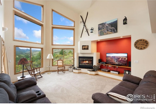 366 N Rim Rd, Livermore, CO 80536 - living room with a towering ceiling, carpet flooring, a glass covered fireplace, and healthy amount of natural light
