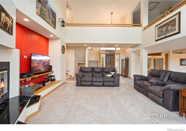 366 N Rim Rd, Livermore, CO 80536 - carpeted living area with a towering ceiling, a glass covered fireplace, and recessed lighting