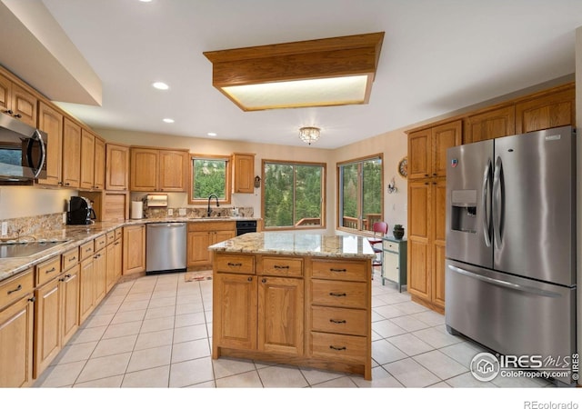 366 N Rim Rd, Livermore, CO 80536 - kitchen with stainless steel appliances, light tile patterned flooring, light stone counters, a kitchen island, and recessed lighting