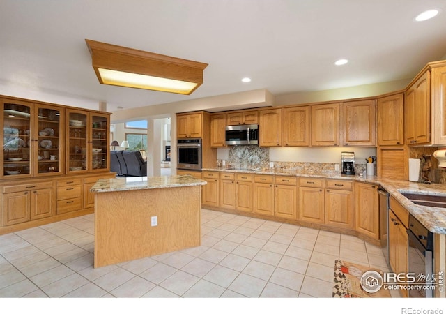366 N Rim Rd, Livermore, CO 80536 - kitchen with appliances with stainless steel finishes, a center island, light tile patterned floors, light stone countertops, and tasteful backsplash