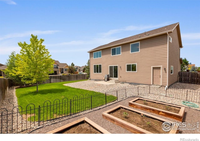 7266 Andover St, Wellington, CO 80549 - back of house featuring a vegetable garden, a fenced backyard, a patio, and entry steps