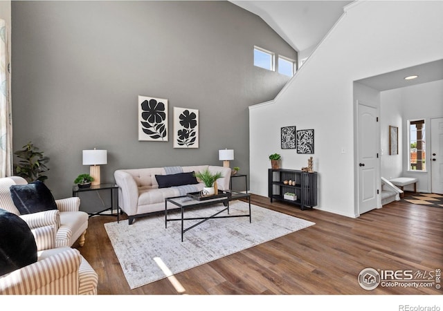7266 Andover St, Wellington, CO 80549 - living area featuring healthy amount of natural light, wood finished floors, and lofted ceiling