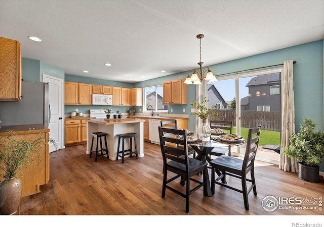 7266 Andover St, Wellington, CO 80549 - dining area featuring dark wood-style floors, plenty of natural light, a chandelier, and recessed lighting