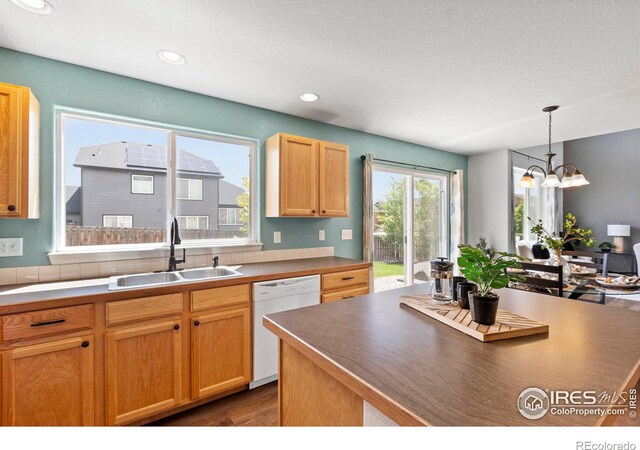 7266 Andover St, Wellington, CO 80549 - kitchen featuring white dishwasher, dark wood-style floors, hanging light fixtures, recessed lighting, and a chandelier