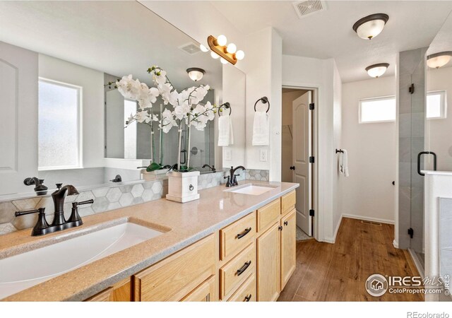 7266 Andover St, Wellington, CO 80549 - bathroom featuring wood finished floors, double vanity, and a stall shower
