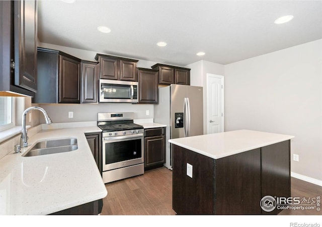 5562 Bristow Rd, Timnath, CO 80547 - kitchen with appliances with stainless steel finishes, dark brown cabinetry, dark wood-type flooring, a center island, and recessed lighting