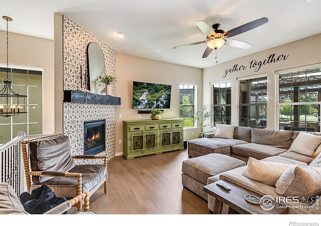 2050 Vineyard Dr, Windsor, CO 80550 - living area featuring ceiling fan, wood finished floors, a tiled fireplace, and a chandelier