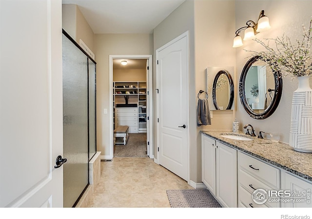 2050 Vineyard Dr, Windsor, CO 80550 - bathroom with vanity, a shower stall, and a walk in closet