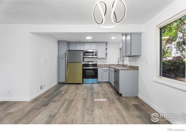 1111 Wabash St, Denver, CO 80220 - kitchen with appliances with stainless steel finishes, light wood-type flooring, gray cabinets, open shelves, and recessed lighting