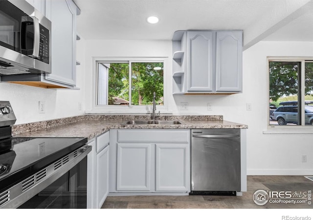 1111 Wabash St, Denver, CO 80220 - kitchen featuring appliances with stainless steel finishes, open shelves, healthy amount of natural light, wood finished floors, and recessed lighting