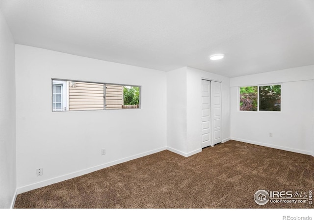 1111 Wabash St, Denver, CO 80220 - unfurnished bedroom with dark carpet, multiple windows, a closet, and recessed lighting