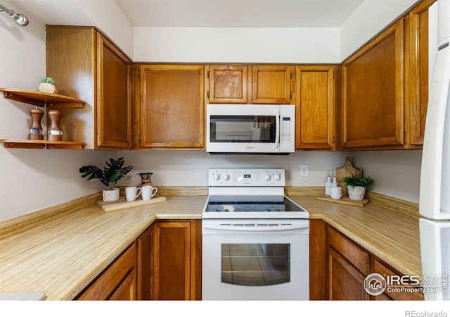 4255 Westshore Way Unit 19, Fort Collins, CO 80525 - kitchen featuring white appliances, light countertops, brown cabinets, and open shelves