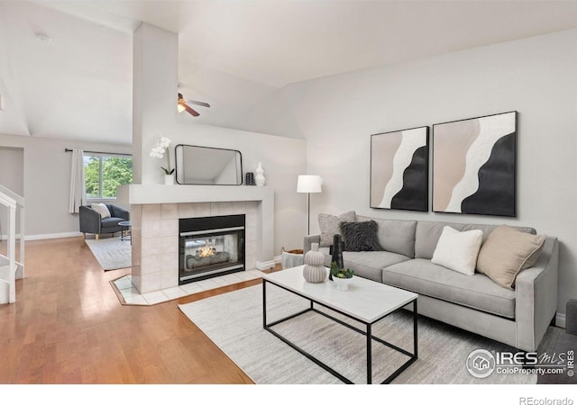 1667 Reliance Cir, Superior, CO 80027 - living room featuring ceiling fan, lofted ceiling, wood finished floors, and a tiled fireplace