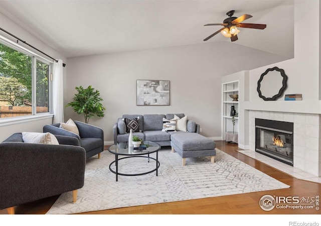 1667 Reliance Cir, Superior, CO 80027 - living room featuring wood finished floors, ceiling fan, vaulted ceiling, and a tile fireplace