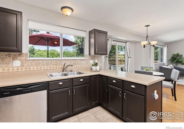1667 Reliance Cir, Superior, CO 80027 - kitchen with stainless steel dishwasher, a peninsula, light countertops, and decorative backsplash