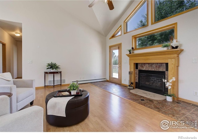 8943 Gander Valley Ln, Windsor, CO 80550 - living area featuring a fireplace, wood finished floors, a baseboard radiator, a ceiling fan, and high vaulted ceiling